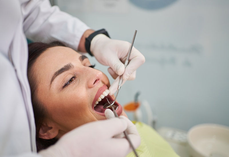 A woman is getting treatment for periodontal disease by Reiser Dental in Denver, CO
